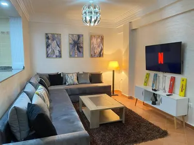 a living room with a couch and a table at studio, à proximité de la gare in Marrakech