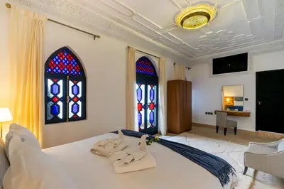 a bedroom with a bed with two stained glass windows at The Grand Riad and Spa in Marrakech