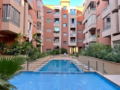 a swimming pool in an apartment complex with buildings at Bel Appartement à Marrakech en Résidence avec Piscine - Fibre & Netflix in Marrakech