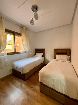 a bedroom with two beds and a window at Bel Appartement à Marrakech en Résidence avec Piscine - Fibre & Netflix in Marrakech