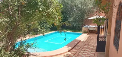 a swimming pool with a tennis court in a yard at Villa Korima in Marrakech