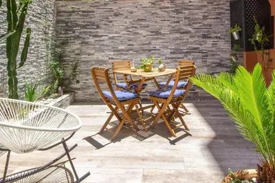 a wooden table and chairs on a patio at Luxury Duplex - Private Jacuzzi - Center Hivernage in Marrakech