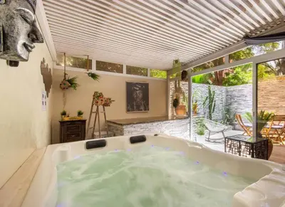 a large bath tub in a room with a large window at Luxury Duplex - Private Jacuzzi - Center Hivernage in Marrakech
