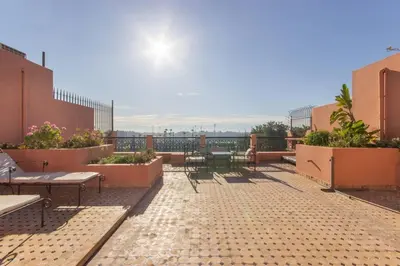 a patio with benches and tables on a building at Luxury Duplex - Private Jacuzzi - Center Hivernage in Marrakech