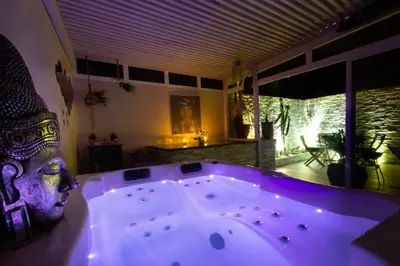 a bath tub with a statue of a head in a room at Luxury Duplex - Private Jacuzzi - Center Hivernage in Marrakech