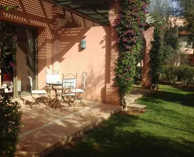 a patio with chairs and a table in a yard at NEW appartement in palmeraie in Marrakech