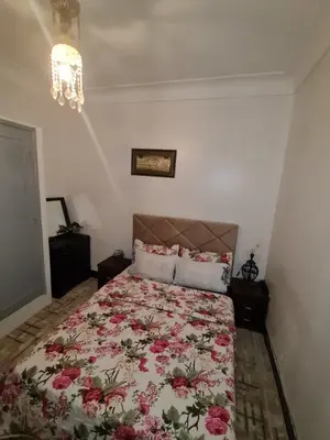 a bedroom with a bed with a floral bedspread at Marrakech in Marrakech