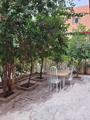 a table and chairs sitting next to some trees at Marrakech in Marrakech