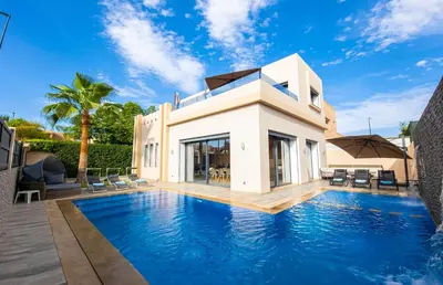 a swimming pool in front of a villa at Villa HAW Marrakech in Marrakech