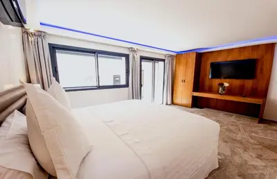 a bedroom with a large white bed with a flat screen tv at Villa HAW Marrakech in Marrakech