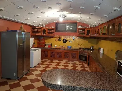 a kitchen with a refrigerator and a checkered floor at Villa Amerchiche in Marrakech