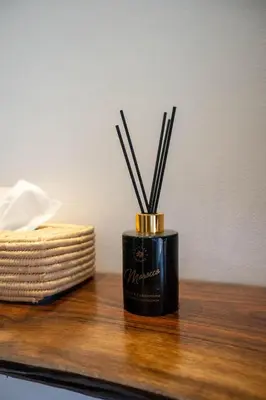 a black container with sticks in it on a table at L'appart by Louhou Collection in Marrakech