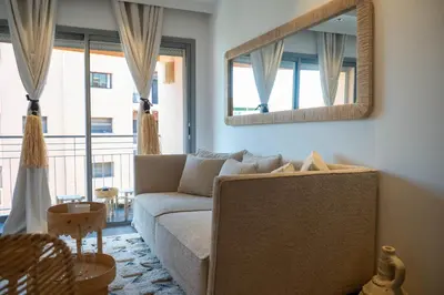 a living room with a couch and a mirror at L'appart by Louhou Collection in Marrakech
