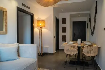 a living room with a couch and a table with chairs at L'appart by Louhou Collection in Marrakech