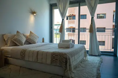 a bedroom with a bed and a large window at L'appart by Louhou Collection in Marrakech