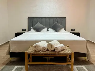 a bedroom with a large bed with towels on a bench at Al Badiya Marrakech in Marrakech