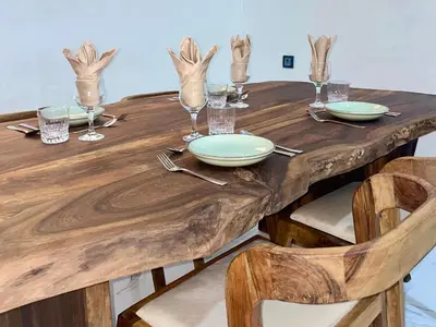 a wooden table with plates and glasses on it at Al Badiya Marrakech in Marrakech