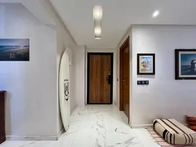 a hallway with a door and a surfboard on the wall at Al Badiya Marrakech in Marrakech