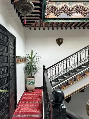 a staircase in a house with a potted plant at Riad Tesnime in Marrakech