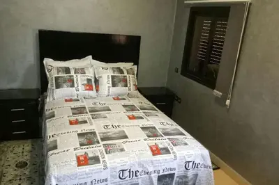 a bedroom with a bed with a newspaper on it at Appartement centre de Marrakech in Marrakech