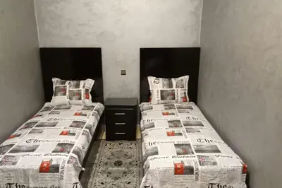 two beds in a small room with newspapers at Appartement centre de Marrakech in Marrakech