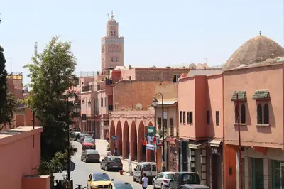 a city street with cars and a clock tower at Appartement centre de Marrakech in Marrakech