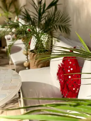 a table with a red vase with a plant on it at Riad Dollar Des Sables & Spa in Marrakech