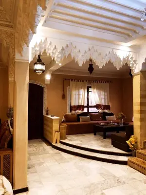 a living room with a couch and a table at maison d'hôtes Le petit jardin Marrakech in Marrakech