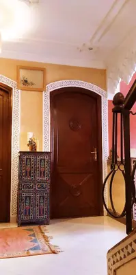 a room with a wooden door and a rug at maison d'hôtes Le petit jardin Marrakech in Marrakech