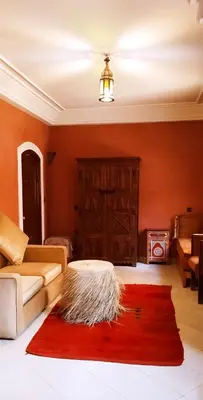 a living room with a couch and a red rug at maison d'hôtes Le petit jardin Marrakech in Marrakech