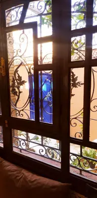 a window with a blue vase sitting on a balcony at maison d'hôtes Le petit jardin Marrakech in Marrakech