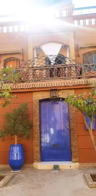 a blue door on a building with a balcony at maison d'hôtes Le petit jardin Marrakech in Marrakech