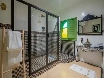 a bathroom with a shower and a tub and a sink at Riad Dar Sido in Marrakech