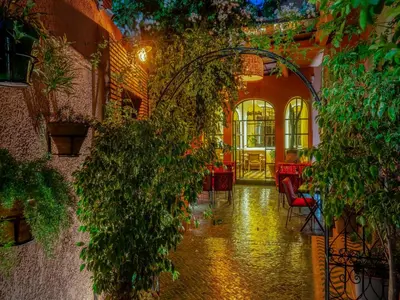 a hallway with plants and a table and chairs at Riad Dar Sido in Marrakech