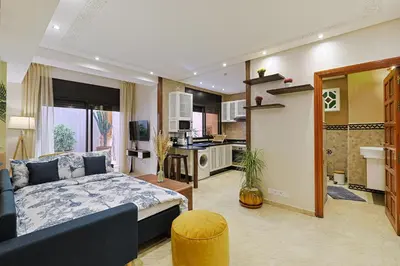a living room with a bed and a kitchen at Oasis - Appartement Authentique à Gueliz in Marrakech