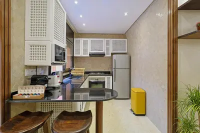 a kitchen with a counter with chairs in it at Oasis - Appartement Authentique à Gueliz in Marrakech