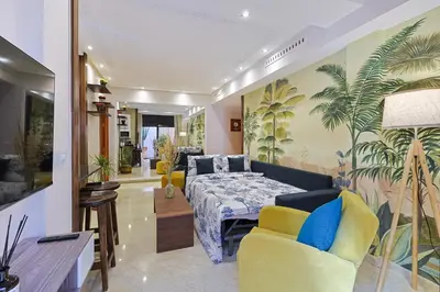 a bedroom with a bed and a couch and chairs at Oasis - Appartement Authentique à Gueliz in Marrakech