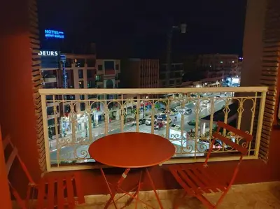 a balcony with a table and a view of a city at Appartement gueliz in Marrakech