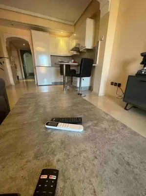 two remote controls sitting on the floor of a living room at Appartement gueliz in Marrakech