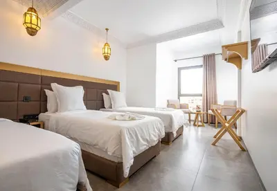 a hotel room with two beds with white sheets at Fashion Boutique Hotel in Marrakech