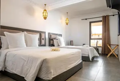 a bedroom with two beds with white sheets at Fashion Boutique Hotel in Marrakech