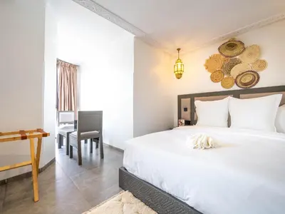 a bedroom with a white bed and a desk at Fashion Boutique Hotel in Marrakech