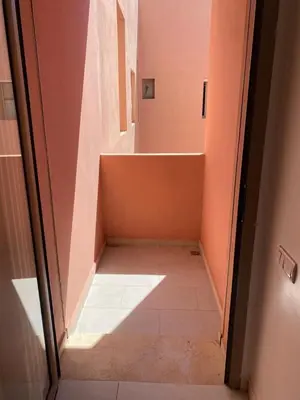 a hallway with a staircase in a room with pink walls at Cosy studio au centre de Marrakech Netflix in Marrakech