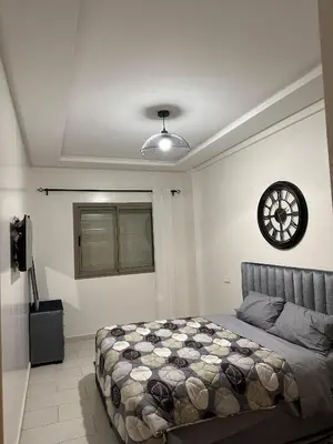a bedroom with a bed and a clock on the wall at Cosy studio au centre de Marrakech Netflix in Marrakech