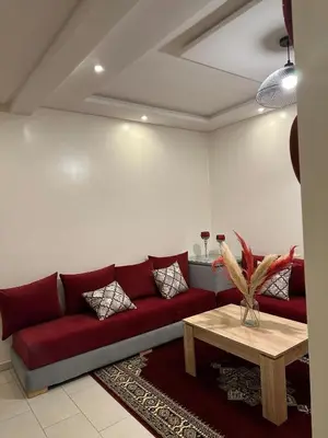 a living room with a red couch and a table at Cosy studio au centre de Marrakech Netflix in Marrakech