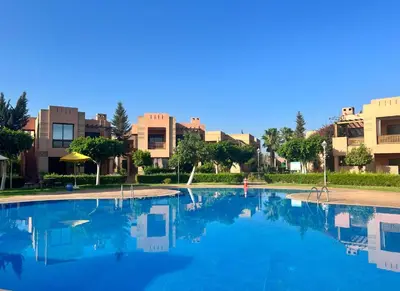 a large swimming pool with buildings in the background at Bright condo w/ pool in Marrakech