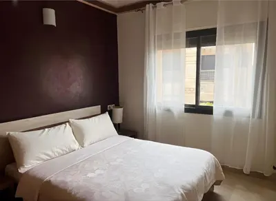 a bedroom with a white bed and a window at Bright condo w/ pool in Marrakech