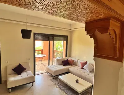 a living room with a couch and a table at Bright condo w/ pool in Marrakech