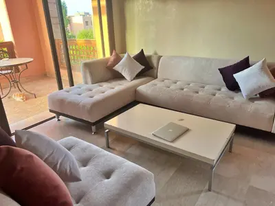 a living room with a couch and a coffee table at Bright condo w/ pool in Marrakech