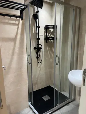 a shower with a glass door next to a sink at Duplex Centre-ville Guéliz in Marrakech